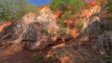 Yavaş çekim yap. Bir aile, Güney Vietnam 'daki Mui Ne köyündeki çöl sınırında kırmızı bir kanyon ya da peri deresi boyunca yürür. Telefonla vurulmuş.