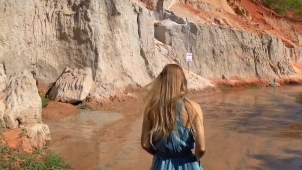Colpo di rallentamento. Una turista donna sta visitando il canyon rosso o Fata flusso al confine del deserto nel villaggio di Mui Ne nel sud del Vietnam. Girato su un telefono — Video Stock