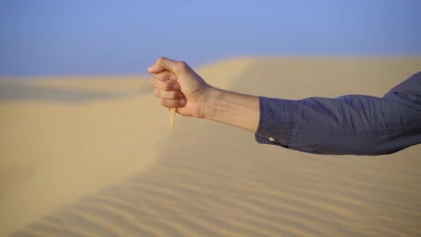 Colpo di rallentamento di una sabbia che fuoriesce da una mano di uomo — Video Stock