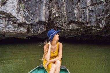 Tam Coc gölündeki kadın turist, Ninh Binh, Vietnam. UNESCO Dünya Mirası Alanı 'dır ve tekne mağarası turlarıyla ünlüdür. Vietnam topraklarındaki Halong Körfezi. Vietnam sonra sınırları yeniden açıyor
