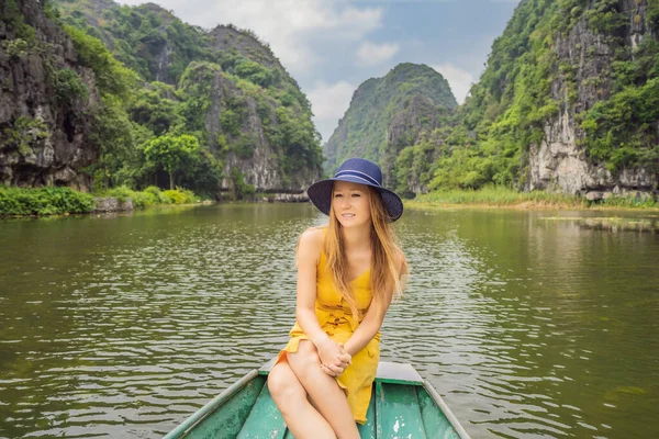 Mulher turista em barco no lago Tam Coc, Ninh Binh, Vietnã. É Património Mundial da UNESCO, conhecido por seus passeios de barco caverna. Sua baía de Halong na terra do Vietnã. Vietname reabre fronteiras após — Fotografia de Stock