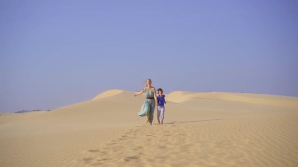 Fotografía en cámara lenta de una joven mujer y un niño divirtiéndose en un desierto — Vídeos de Stock