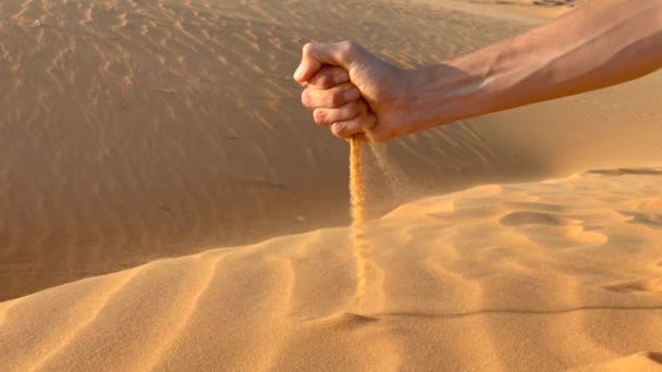 Langzame opname van een zand dat uit een mensenhand stroomt — Stockvideo