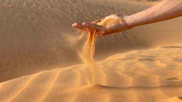Медленная съемка песка, который льется из рук человека — стоковое видео