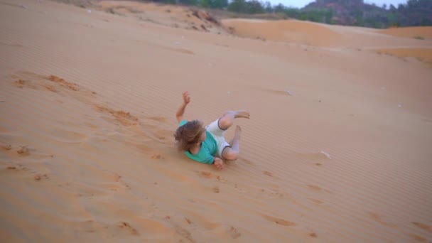 Slow motion shot van een kleine jongen is plezier hebben in een woestijn — Stockvideo