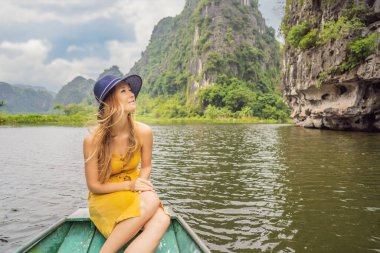 Tam Coc gölündeki kadın turist, Ninh Binh, Vietnam. UNESCO Dünya Mirası Alanı 'dır ve tekne mağarası turlarıyla ünlüdür. Vietnam topraklarındaki Halong Körfezi. Vietnam sonra sınırları yeniden açıyor