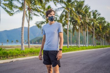 Tıbbi maske takan bir kaçakçı, Coronavirüs salgını Covid-19. Spor, karantinada aktif yaşam yüz maskesi korumalı cerrahi sterilizasyon. Corona Salgını 'nda atletizm pistinde açık hava koşusu