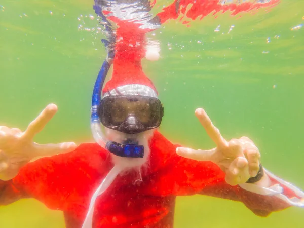 Tomten snorklar under vattnet - jul eller gott nytt år koncept. Julen i tropikerna efter karantänen lyftes Coronovirus COVID 19 koncept — Stockfoto