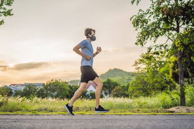 Tıbbi maske takan bir kaçakçı, Coronavirüs salgını Covid-19. Spor, karantinada aktif yaşam yüz maskesi korumalı cerrahi sterilizasyon. Corona Salgını 'nda atletizm pistinde açık hava koşusu