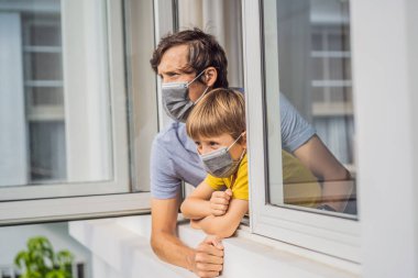 Aşırı yorgun baba ve oğul pencereden dışarı bakıyor, evde yalnız. Evde kendini izole etme, salgın COVID 19 yüzünden karantina. Evde kendini izole etme, karantina, izolasyon gibi zihinsel sağlık sorunları