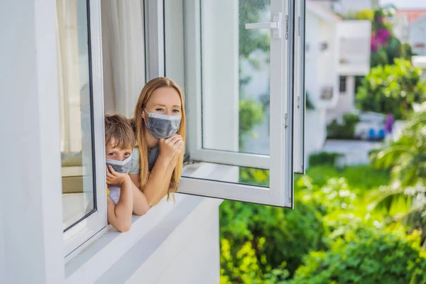 Extremly tired Mother and son looking out the window, home alone. self-isolation at home, quarantine due to pandemic COVID 19. Mental health problems in self-isolation at home, quarantine, isolation — Stock Photo, Image