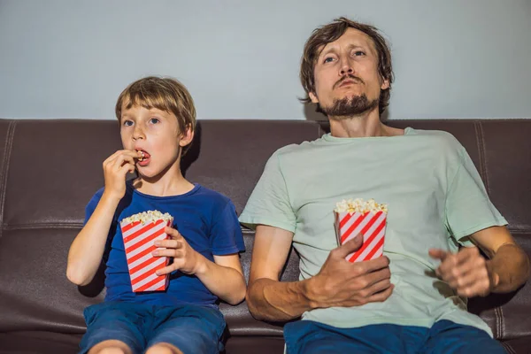 Father and son watching TV and eat popcort in evening at home — Stock Photo, Image