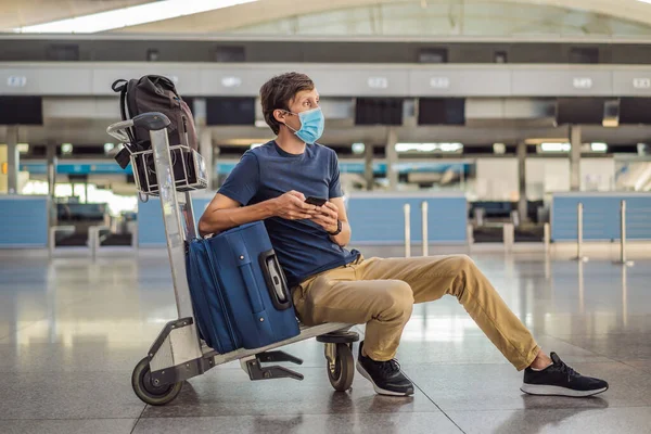 Maskierter Mann am leeren Flughafen beim Check-in in Coronavirus-Quarantäne-Isolation, Heimkehr, Flugausfall, weltweite Ausbreitung der Pandemie, Reisebeschränkungen und Grenzschließung — Stockfoto