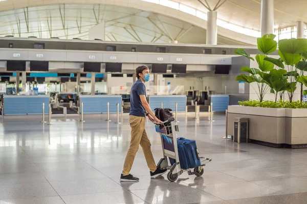 Maskierter Mann am leeren Flughafen beim Check-in in Coronavirus-Quarantäne-Isolation, Heimkehr, Flugausfall, weltweite Ausbreitung der Pandemie, Reisebeschränkungen und Grenzschließung — Stockfoto