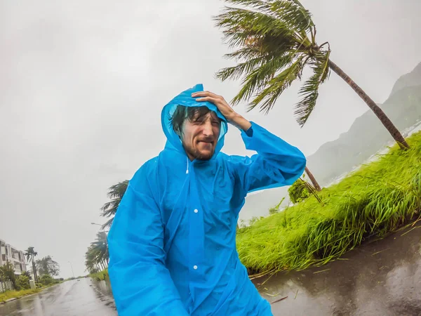 熱帯低気圧、大雨、熱帯性気候の強風の間のレインコートの男 — ストック写真