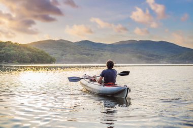 Yaz Gezisi Kayağı. Man Paddling Şeffaf Kano Kayağı, Eğlence Sporları Aktivitesinin tadını çıkarıyor. Kürekli Erkek Kano, Tatilde Denizi Keşfediyor. Kürek çeken Su Sporları
