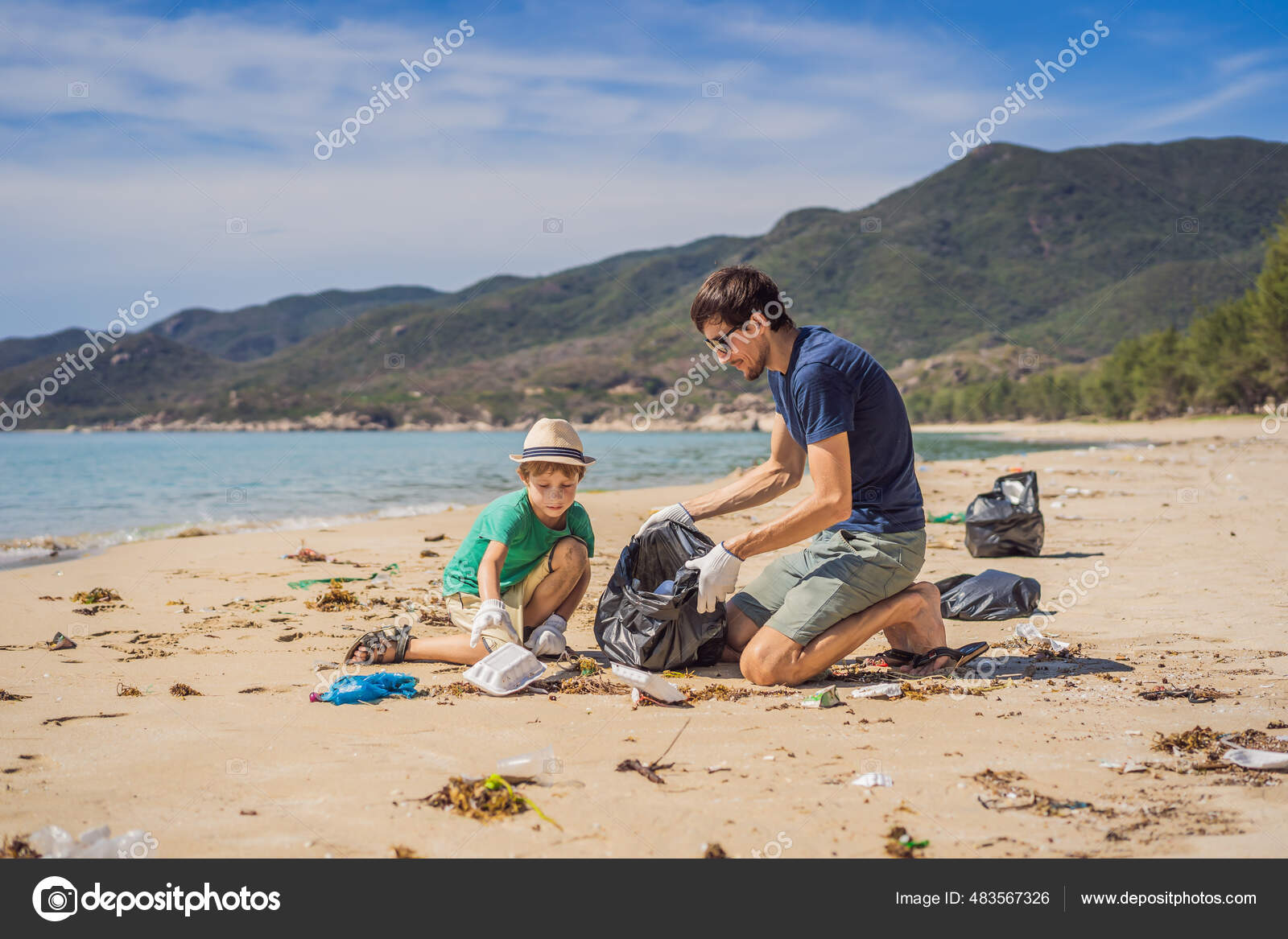 O pai e o filho de luvas a limpar a praia apanham sacos de plástico que
