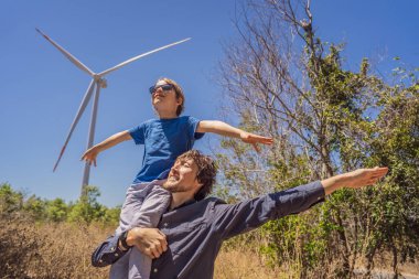 Alternatif enerji, rüzgar çiftliği ve ailenle mutlu zaman geçirmek. Oğlunu omuzlarında taşıyan mutlu baba tatilde ve doğaya kaçıyor. Baba oğlunu omuzlarında taşır ve kollarını sallar.