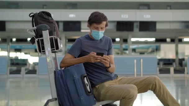 Pria bertopeng di bandara kosong di cek in di isolasi karantina coronavirus, kembali ke rumah, pembatalan penerbangan, infeksi pandemi di seluruh dunia menyebar, pembatasan perjalanan dan penutupan perbatasan — Stok Video