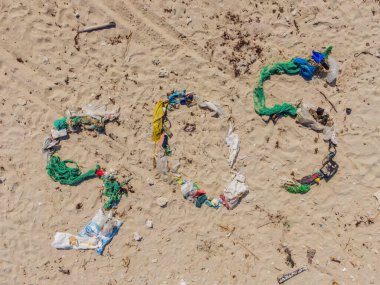 Çevresel bir sorun. Ekoloji konsepti. Plastik plajda yazılar var. Sahile çöp döktüm.
