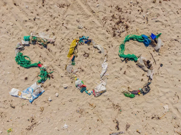 Проблемы окружающей среды. Экологическая концепция. Пластик на пляже с надписью Sos. Разбросанный мусор на пляже — стоковое фото