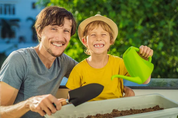 Papà e figlio fanno giardinaggio sul balcone. Sviluppo naturale per i bambini — Foto Stock