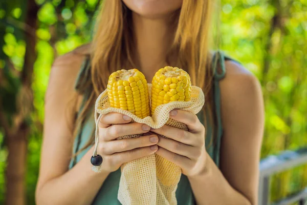 Maïs in een herbruikbare zak in de handen van een jonge vrouw. Nul afvalconcept — Stockfoto