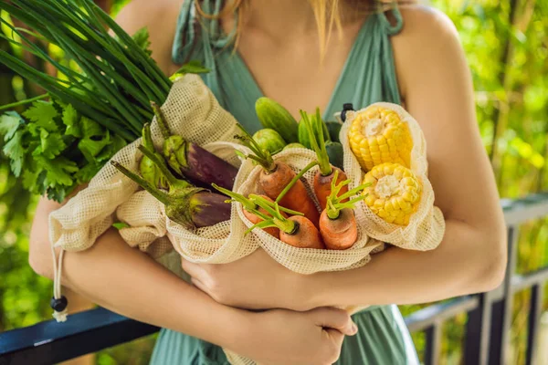 Verse groenten in een herbruikbare zak in de handen van een jonge vrouw. Nul afvalconcept — Stockfoto