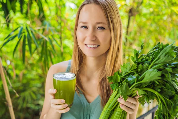 Young woman drinks Celery Juice, Healthy Drink, bunch of celery on a wooden background — Stock Photo, Image
