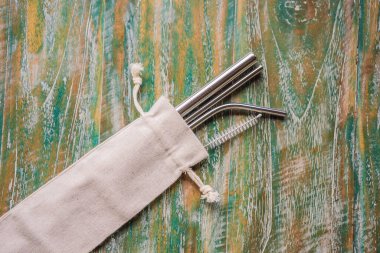 Çelik pipetler boyalı ahşap arka planda. Sıfır atık