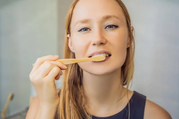 Young and caucasian woman brushing her teeth with a bamboo toothbrush — Stock Photo, Image