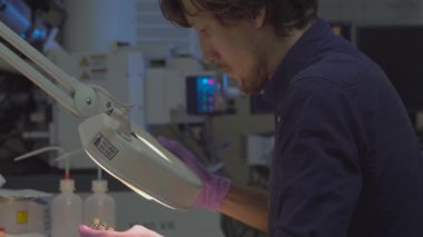 Laboratuvardaki bilim adamları elektron mikroskobu araştırması için örnekler hazırlıyorlar.