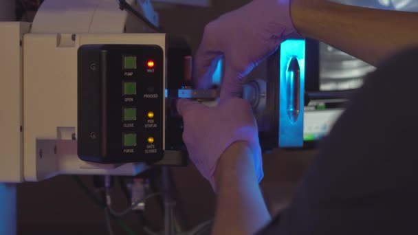 Cientista em um laboratório colocar amostras em microscópio eletrônico para investigação — Vídeo de Stock
