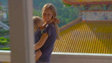 Genç bir kadın ve küçük oğlu Malezya 'nın Penang adasındaki Kek Lok Si Budist tapınağını ziyaret ediyor.