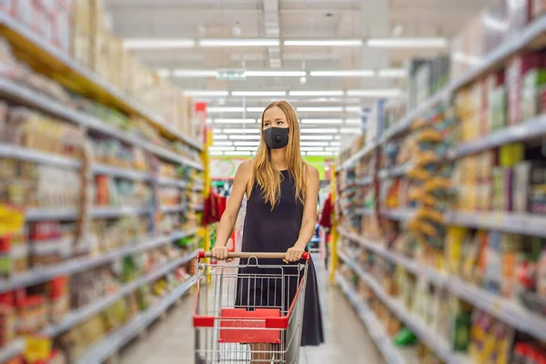 Donna allarmata indossa maschera medica contro il coronavirus mentre fa la spesa al supermercato o al supermercato- salute, sicurezza e concetto di pandemia - giovane donna con maschera protettiva e stoccaggio di cibo — Foto Stock