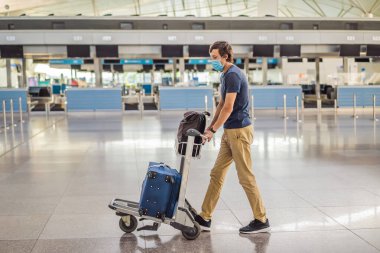 Koronavirüs karantinasında kontrol altında tutulan maskeli adam, eve dönüyor, uçuş iptali, dünya çapında yayılan salgın hastalık, seyahat kısıtlamaları ve sınır kapatma.