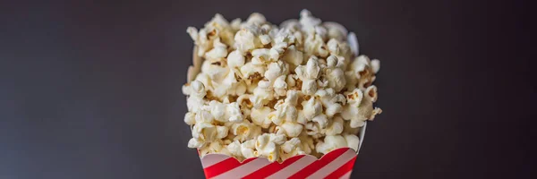 Popcorn in red and white container on a dark background BANNER, LONG FORMAT — Stock Photo, Image