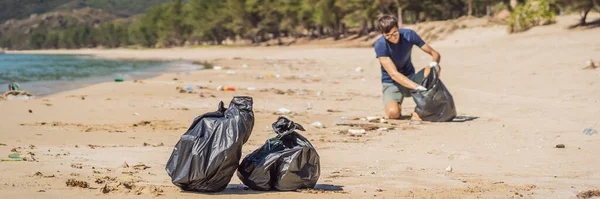 장갑을 낀 먼 옛날의 남자 가 바다를 오염시키는 비닐봉지를 집는다. 인간이 만든 오염 과 환경으로 인해 해변 모래에 쓰레기를 쏟아 버린 문제, 청소 운동 — 스톡 사진