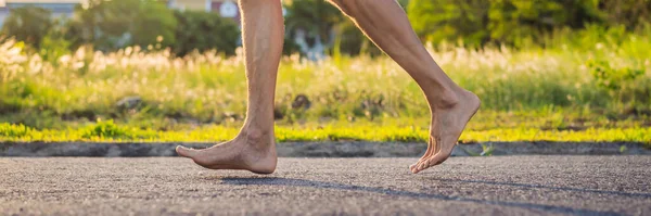 男のランナーは、靴なしでアスファルトの上にジョギングに従事しています,スニーカーなし,健康のためのバナー,ロングフォーマット — ストック写真