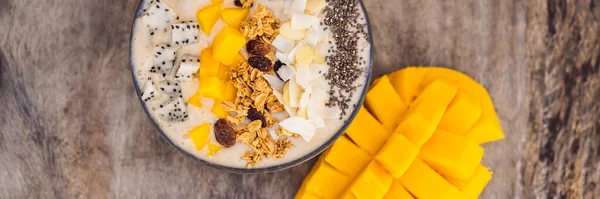 BANNER, FORMATO LARGO Cuencos de batido hechos con mango, plátano, granola, coco rallado, fruta de dragón, semillas de chía y menta sobre fondo de madera. Concepto frutas, vitaminas — Foto de Stock