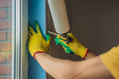 İnşaatçı veya tamirci pencerelerin onarımı veya kurulumu ile meşguldür