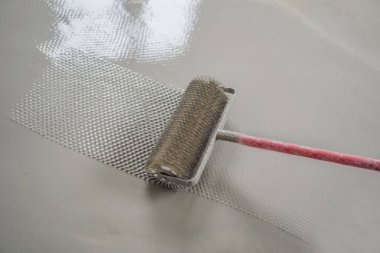 Döşeme kaplaması sırasında alçı, kendi seviyesini yükselten çimento harcı ile çalışır, iğne silindiri kullanır