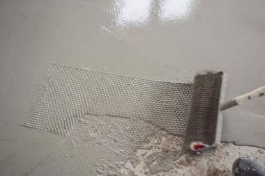 Döşeme kaplaması sırasında alçı, kendi seviyesini yükselten çimento harcı ile çalışır, iğne silindiri kullanır