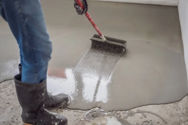 Önterülő cementhabarccsal végzett padlóburkoló munkák során tűgörgőt használ — Stock Fotó