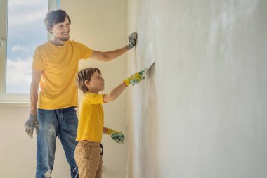 Oğluyla evde tamirat yapan bir adam, çocuklara ellerinde bir spatulayla duvarları alçılamayı öğretiyor.
