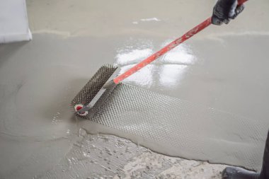 Döşeme kaplaması sırasında alçı, kendi seviyesini yükselten çimento harcı ile çalışır, iğne silindiri kullanır