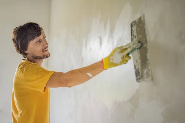 Gipser Heimwerker arbeitet mit Spachtelmesser an Wohnungswandfüllung — Stockfoto