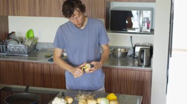 Genç bir adam mutfakta yemek pişiriyor, lezzetli bir ev yemeği hazırlamaya odaklanıyor. Sıcacık bir ortamda ev yapımı, yaratıcılık ve aşçılık keyfi.