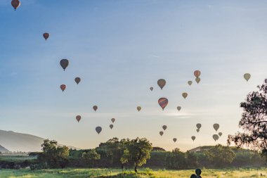 Meksika 'da Teotihuacan' da yüzen renkli sıcak hava balonları antik piramitlerin nefes kesici manzarasını yaratıyor. Turizm, macera ve kültür mirası kavramı.