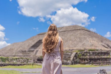 Meksika 'da Teotihuacan piramitlerinin önünde duran kadın turist gezinin, maceranın ve kültürel mirasın tadını çıkarıyor. Seyahat, turizm ve keşif konsepti.